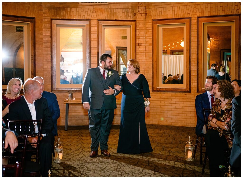 groom and mom walking down aisle at Union Station Banquets