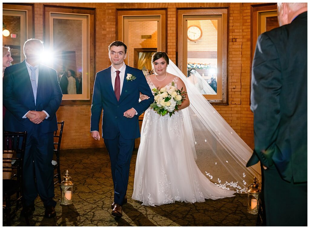 bride and brother walking down aisle at Union Station Banquets