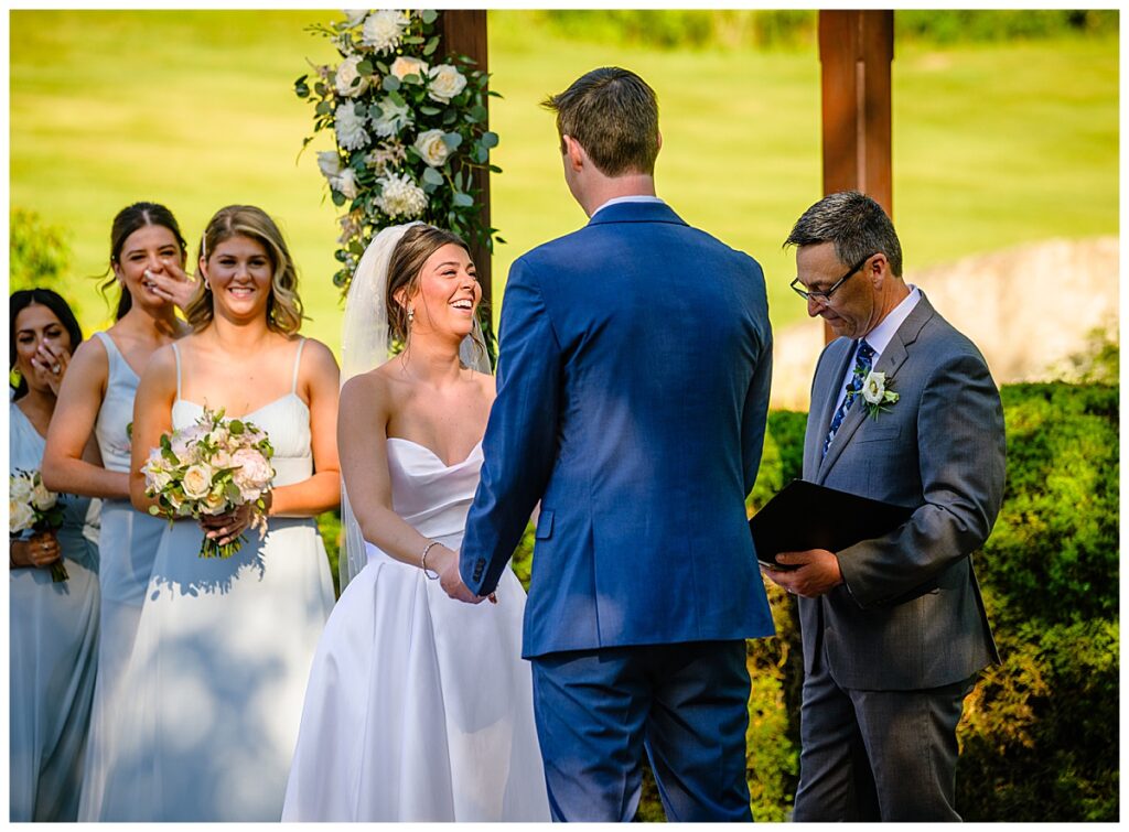 bride and bridesmaids laughing at ceremony