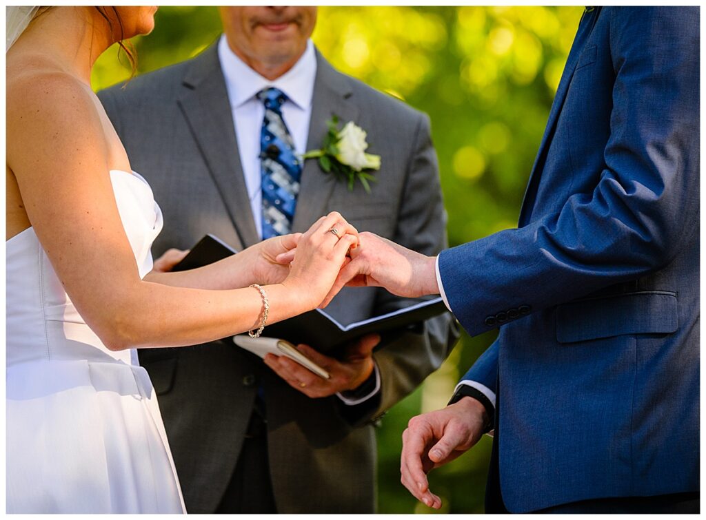 bride putting ring on groom