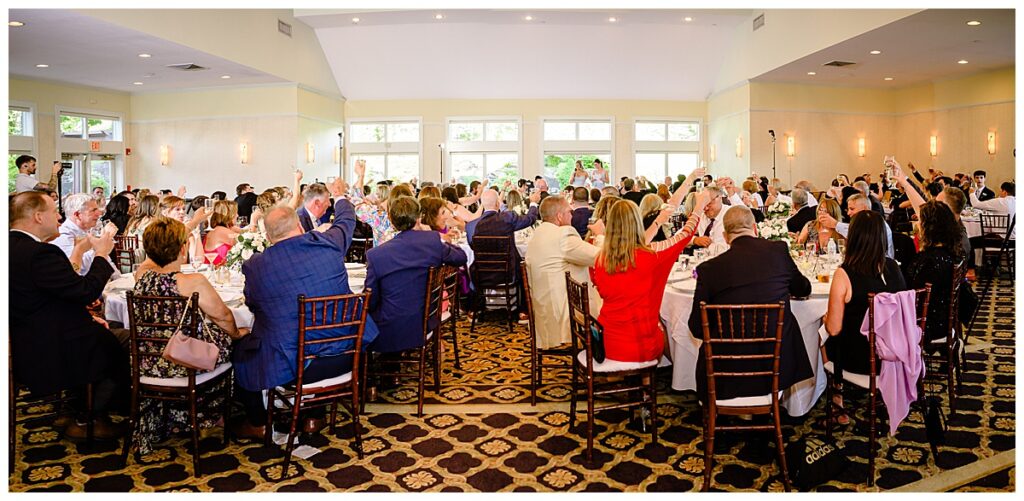 all wedding guests cheering after toast