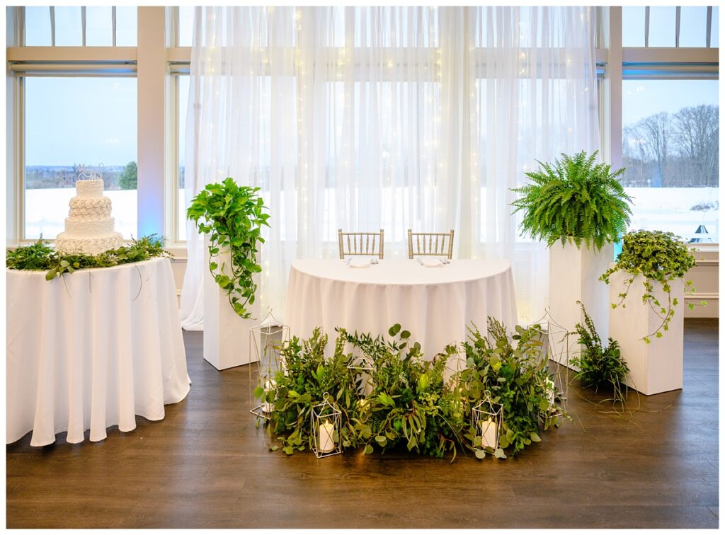 Elegant detail shot of the sweetheart table featuring greenery and romantic lighting at Four Oaks Country Club wedding