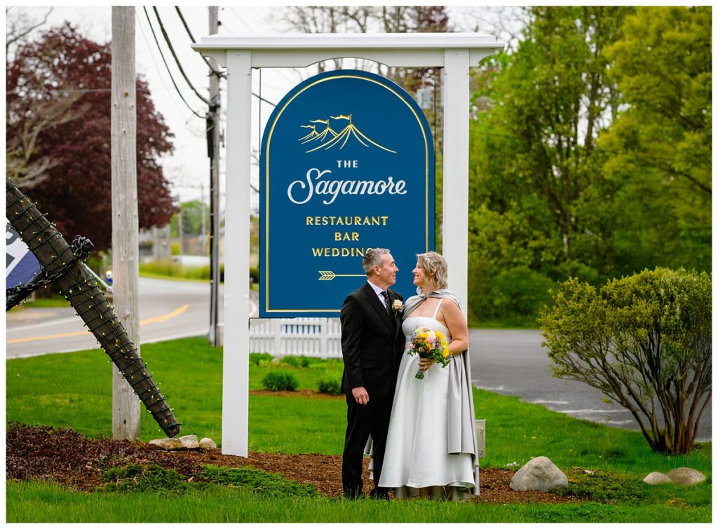 bride and groom in front of Sagamore Inn sign in Sandwich MA
