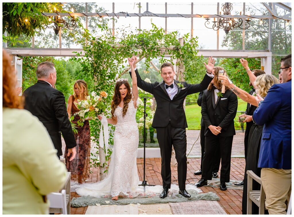 couple celebrating at barn on the pemi wedding ceremony greenhouse