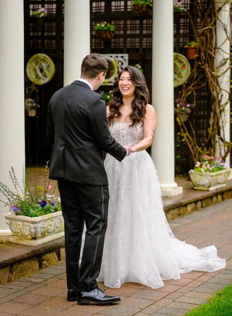 Couple holding hands at first look at Topfields Massachusetts wedding